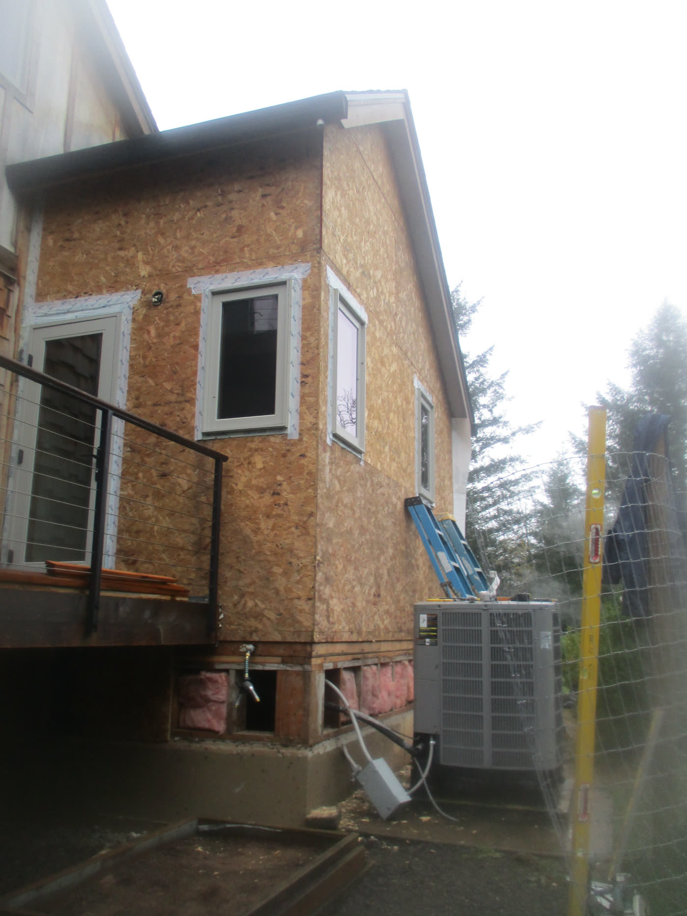 A house with the old siding removed, down to bare sheathing, before new siding goes on